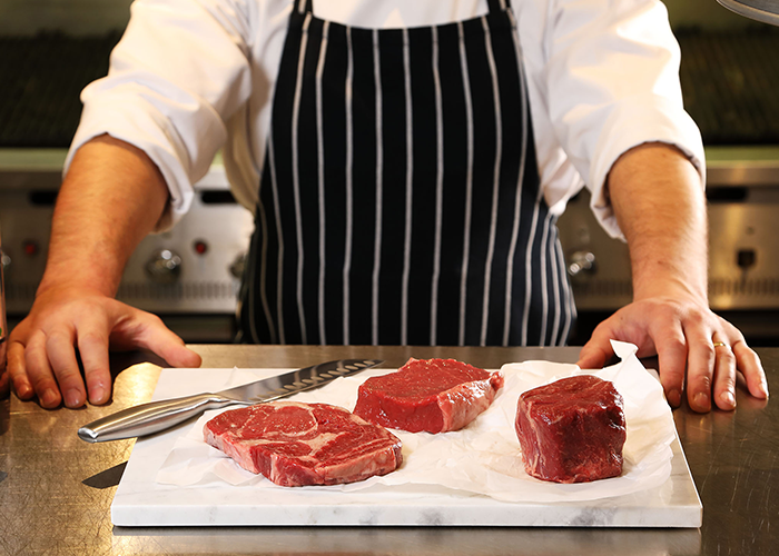 A Miller & Cater chef preparing steak near you in Wilmslow